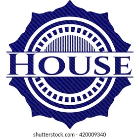 House badge with denim background