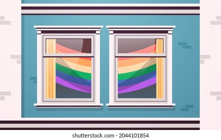 house facade windows decorated with LGBT rainbow flags lesbian gay parade transgender love concept