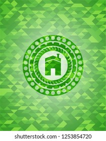 house icon inside green emblem with triangle mosaic background