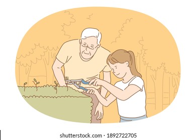 Houseplants and gardening concept. Young smiling girl and grandfather cutting green plant sprouts with special scissors for better growing and taking care of small garden 