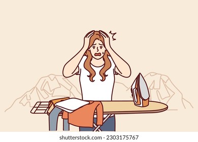 Housewife woman ironing clothes and clutching head in panic due to overload and fatigue. Housewife with iron stands near pile of clothes and needs assistant to take care of household