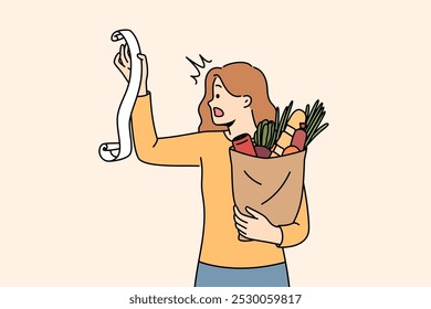 Huge bill for healthy food shocks woman who opens mouth, reading store receipt. Girl with bag healthy food products, disoriented due to sharp inflation of costs for organic fruits and vegetables.