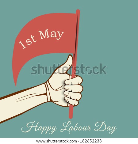 Human hand holding a flag with text 1st May on green background, concept for Happy Labour Day.