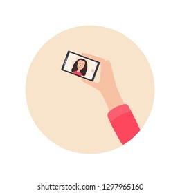 Human hand holding mobile phone and looking at the screen. Vector cartoon illustration of Young beautiful Smiling girl on display smartphone. Woman take a selfie.