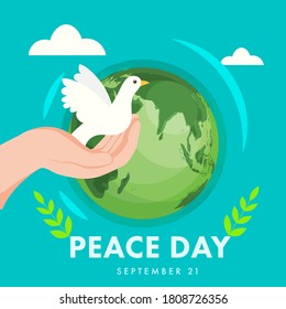 Human Hand Holding Pigeon with Olive Leaves and Earth Globe on Turquoise Background for Peace Day, 21st September.