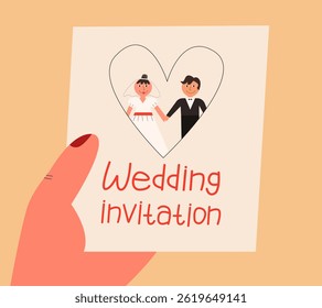 Human hand holds wedding invitation 