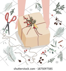 Human hands decorating gift box or parcel wrapped into brown mail paper with fir brunch and birds couple badge. Vector illustration for Christmas, holidays, presents, new year and people concept.