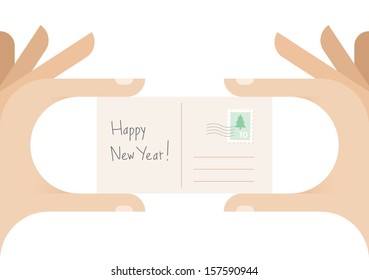 Human hands holding postcard with Christmas tree stamp and "Happy New Year!" text. Idea - New Year congratulation postcard with free space for the name.
