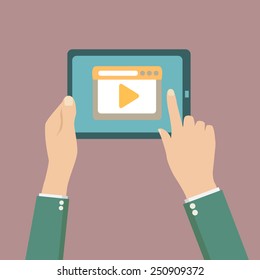 Human hands holding tablet computer with video player on the scr