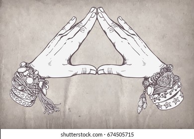 Human hands make triangle shape isolate on white background. Illuminati sign. Sacred geometry. Religion, spirituality, occultism, alchemy magic. Vintage boho style accessories with hippie bracelets.