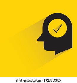 human head and check mark with shadow on yellow background