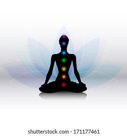 Human silhouette in yoga pose with chakras