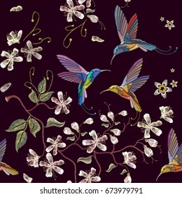 Humming bird and blossoming cherry embroidery seamless pattern. Beautiful hummingbirds and white blossoming cherry sakura flowers on black background. Template for clothes, textiles, t-shirt design 