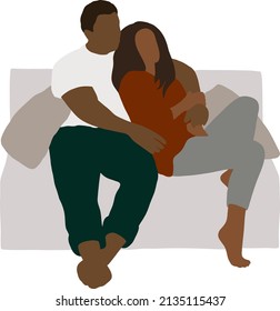 Husband and wife sit hugging on the couch with pillows