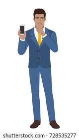 Hush hush. Businessman holding mobile phone and shows hush-hush sign. Full length portrait of Black Business Man in a flat style. Vector illustration.