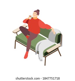 Hygge lifestyle isometric composition with character of relaxing girl sitting on soft couch with hot drink vector illustration
