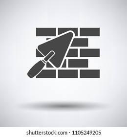Icon of brick wall with trowel on gray background, round shadow. Vector illustration.