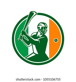 Icon retro style illustration of athlete or player playing Hurling, a Gaelic Irish sport,  striking sliothar ball with hurley wooden stick viewed from side set inside circle with Ireland Irish flag.