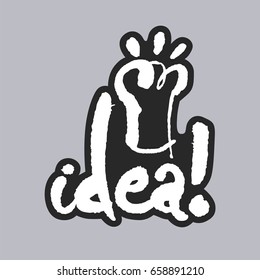Idea. Hand written phrase in calligraphic style on gray background. White on black. Clipping paths included.