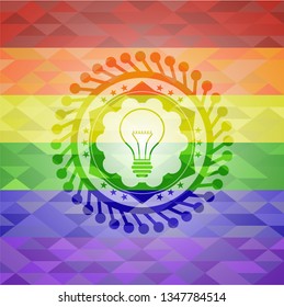 idea icon inside emblem on mosaic background with the colors of the LGBT flag