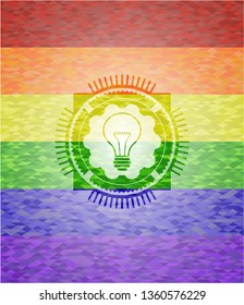 idea icon inside emblem on mosaic background with the colors of the LGBT flag