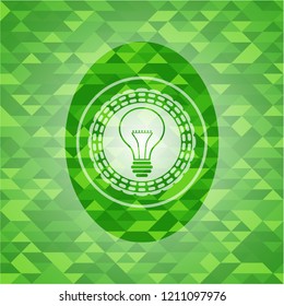 idea icon inside green emblem with triangle mosaic background
