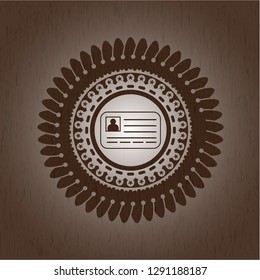 identification card icon inside badge with wooden background