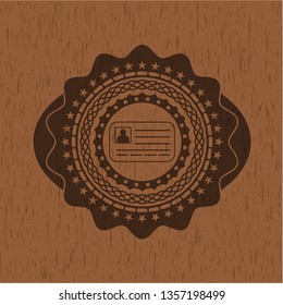 identification card icon inside badge with wood background