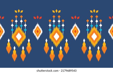 Ikat ethnic background vector. Seamless pattern in white, orange, blue square shapes decorated with colorful tassels and flower petals on dark blue background. 