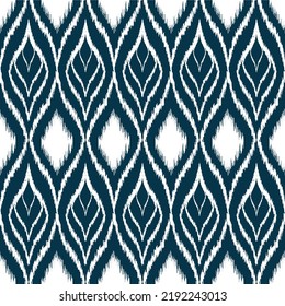 Vector de fondo étnico Ikat. Patrón sin fisuras de formas de diamante blanco y hojas sobre fondo azul marino.