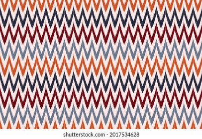 Ikat ethnic zigzag design background. Seamless ikat pattern in tribal, folk embroidery blue orange art. Aztec geometric art ornament print.Design for carpet, wallpaper, clothing, wrapping, fabric.