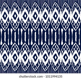 Ikat seamless pattern. Vector tie dye  shibori print with stripes and chevron. Ink textured japanese background.  Ethnic fabric vector. Bohemian fashion. Endless watercolor texture. African rug.