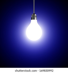 Illuminated light bulb on blue background 