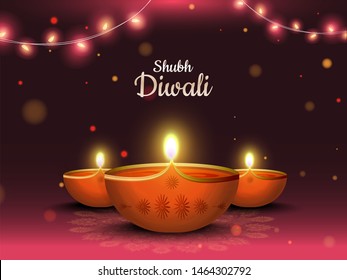 Illuminated oil lamp on shiny lighting brown bokeh background for Diwali festival celebration poster or invitation card design.