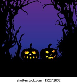 Illuminated pumpkins with space for your Halloween holiday text. Spooky naked trees border background. Backlight scene.