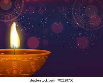 Illuminated, traditional oil lit lamp for Happy Diwali celebrations concept.  