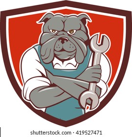 Illustration of a bulldog mechanic with arms crossed holding spanner facing front set inside shield crest on isolated background done in cartoon style.