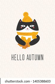 illustration of a cat in a yellow hat with a pompon and a scarf which holds in its paws a large yellow leaf. Hello Autumn text