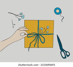 Illustration depicting the process of wrapping a gift for the holiday. Hand packs a gift box