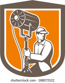 Illustration of a electrical lighting technician crew with fresnel spotlight looking to side set inside shield crest shape on isolated background done in retro style.
