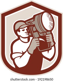 Illustration of a electrical lighting technician crew carry fresnel spotlight on shoulder looking to side set inside shield crest shape on isolated background done in retro style.
