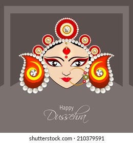 Illustration of the face of Goddess Durga with beautiful eyes wearing a golden nose ring and a heavy colourful crown decorated with red and white pearls.  