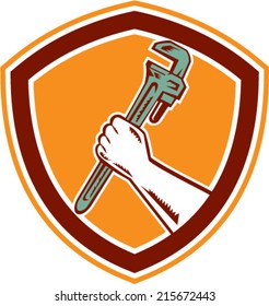 Illustration of a hand holding an adjustable monkey wrench set inside shield crest on isolated background done in retro woodcut style. 