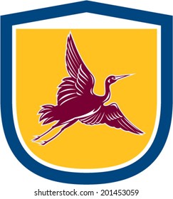 Illustration of a heron crane flying viewed from the side set inside shield crest on isolated background done in retro style.