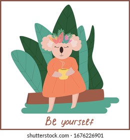 Illustration with a koala sitting with a cup of tea near the tropical leaves. Koala is a cute bear. Handwritten inscription be yourself.