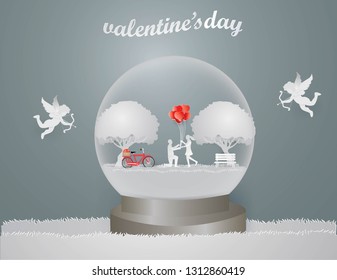 Illustration of love and Valentine day concept,Cupid flies around Lover give a gift as a heart shaped balloon in spring season in Snow globe , paper craft style and illustration 