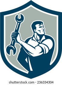 Illustration of a mechanic clinching holding spanner wrench looking to the side set inside shield crest on isolated background done in retro style. 