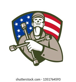 Illustration of a mechanic worker holding tire wrench, 4-way lug wrench, or tyre iron on chest looking up set in shield crest with american usa flag stars and stripes in background done retro style. 