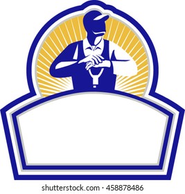 Illustration of organic farmer leaning on shovel looking up to the side viewed from front set inside shield crest with sunburst in the background done in retro style. 