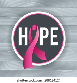 An illustration of a pink Breast Cancer Awareness ribbon and badge with the theme of HOPE. Light grey background of wood boards. Vector EPS 10. EPS file contains gradient mesh and transparencies.